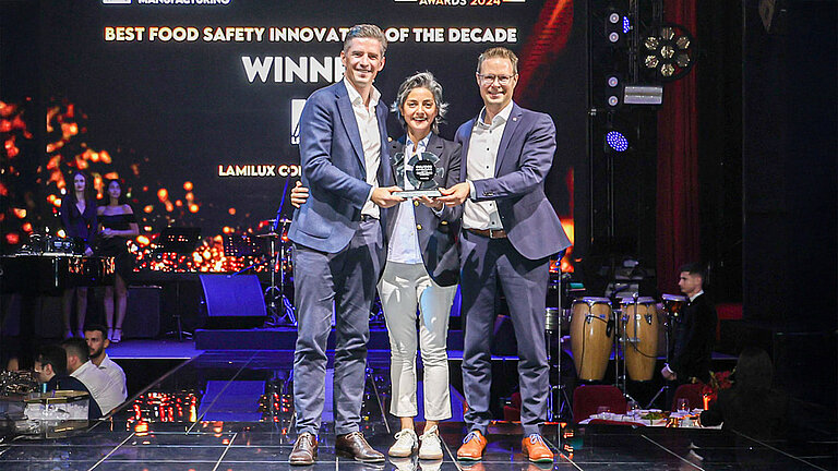 Goli Vossough, Commercial Director im Bereich Food Cluster Exhibitions, überreicht den Award an Dr. Alexander Strunz, Geschäftsführer der LAMILUX, (links) und Alexander Hoier, Head of Business Unit Building & Construction (rechts).