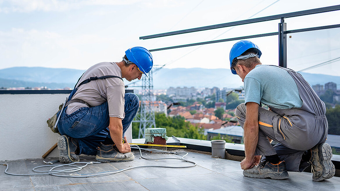 Zwei Handwerker arbeiten an der Ausführung einer Dachterrasse