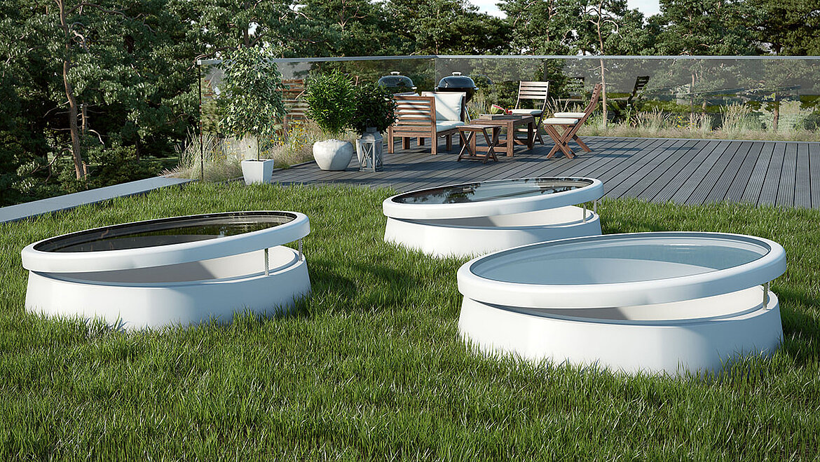 Runde weiße Oberlichter in einer begrünten Dachterrasse mit Gartenmöbeln im Hintergrund