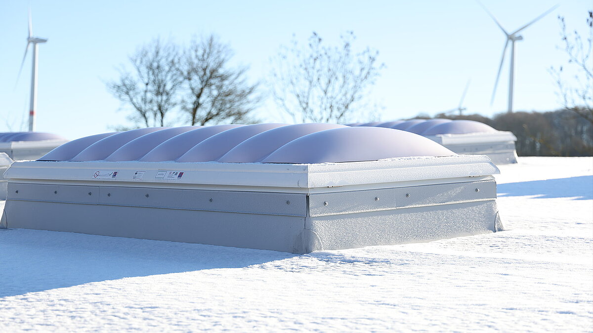 Schneebedeckte Lichtkuppeln auf dem Dach des Gebäudes "Ab in die Box" am Diemelsee.