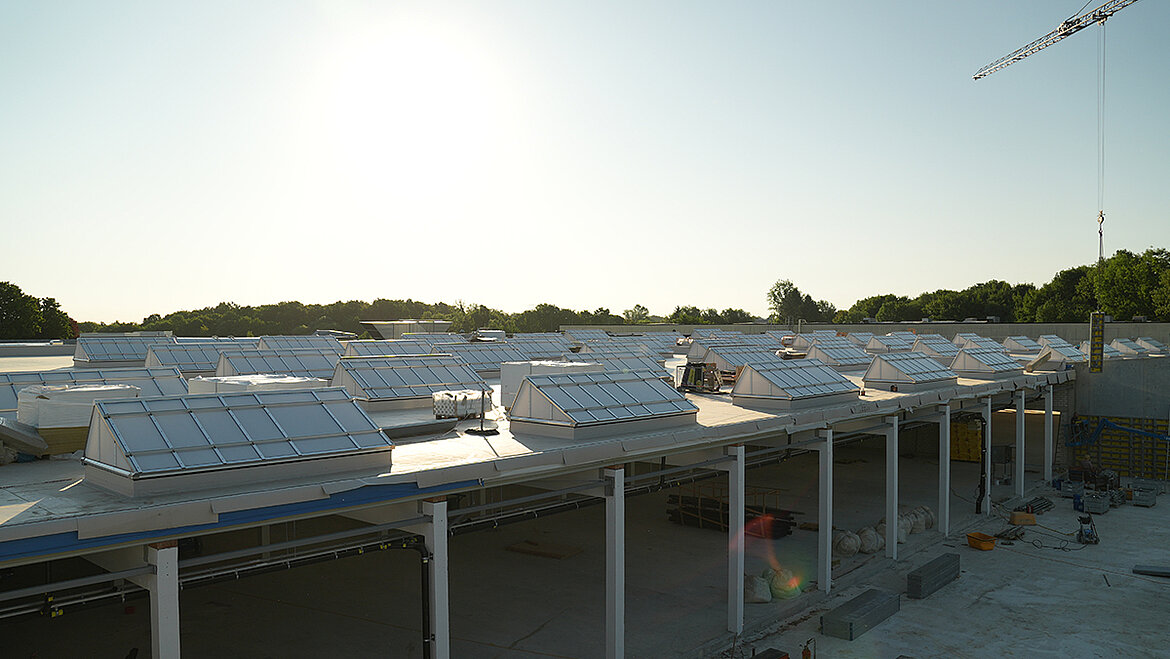Industriegebäude mit zahlreichen Lichtkuppeln auf weitläufigem Flachdach bei Abendlicht
