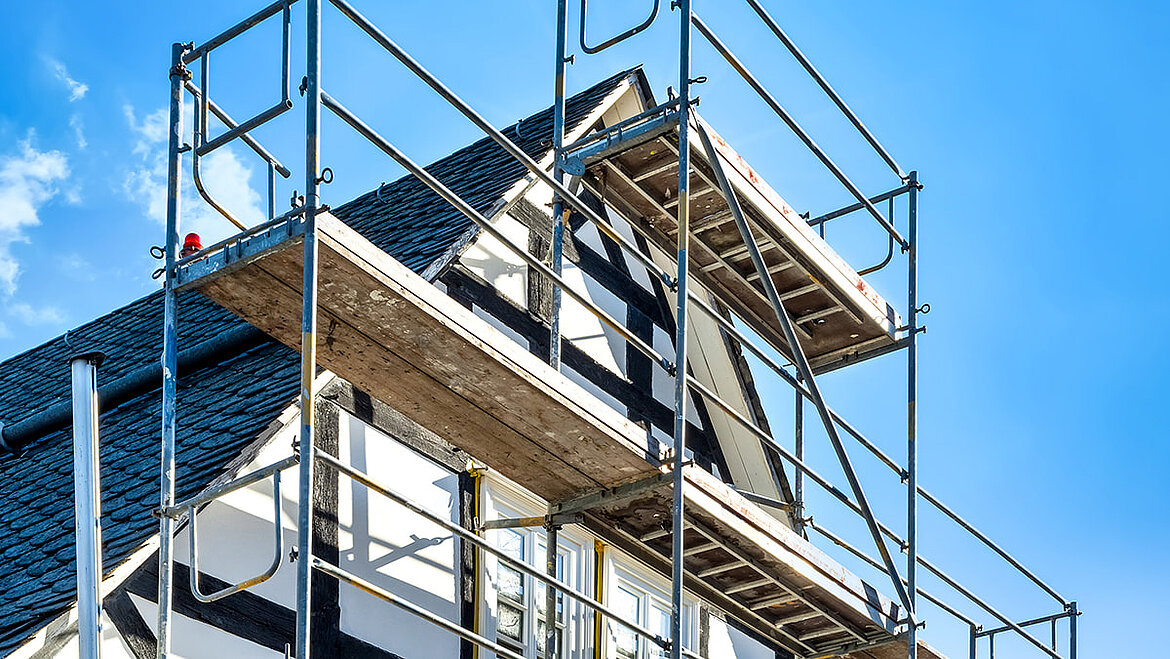Haus mit Baugerüst für Dach- und Fassadenarbeiten