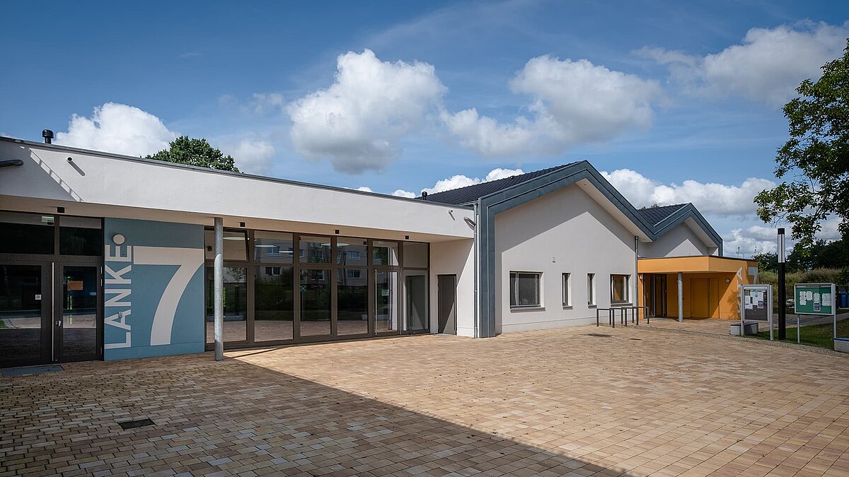 Außenansicht der Kindertagesstätte Sonnenfeld in Wandlitz mit moderner Architektur und großen Glasfronten.