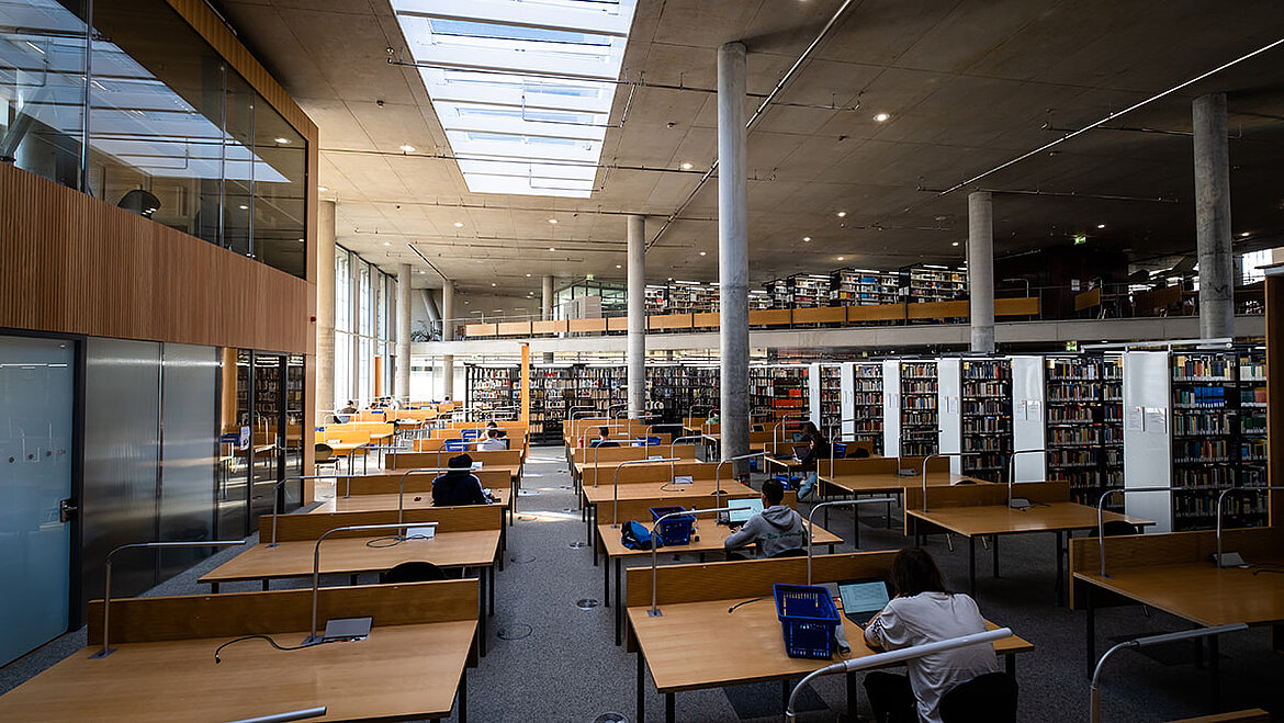 Helle Bibliothek mit Oberlichtern und zahlreichen Arbeitstischen