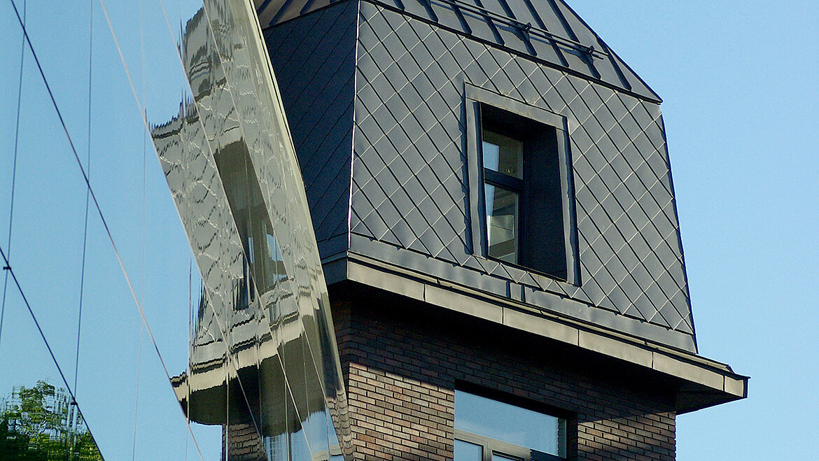 Modernes Gebäude mit verspiegelter Fassade und Dachfenster