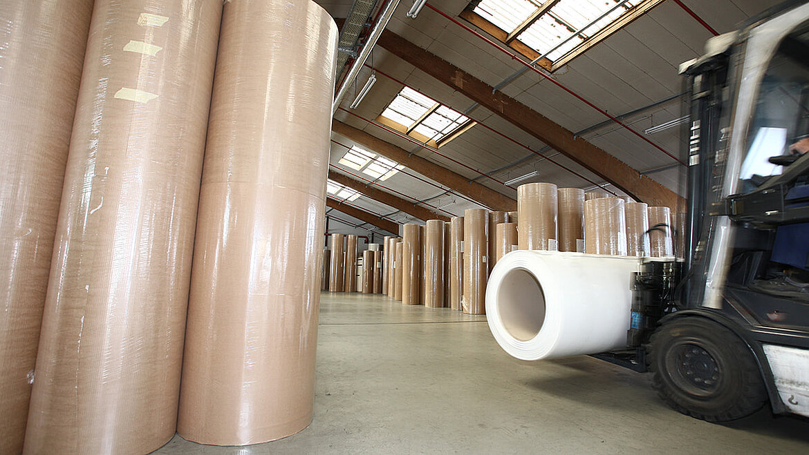 Gabelstapler fährt in Lager mit Kunststoffrollen