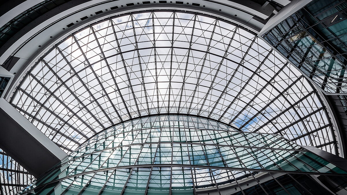 Großflächige, gewölbte Glasdachkonstruktion im BMW Group Forschungs- und Innovationszentrum (FIZ) mit beeindruckendem Lichteinfall und moderner Architektur.