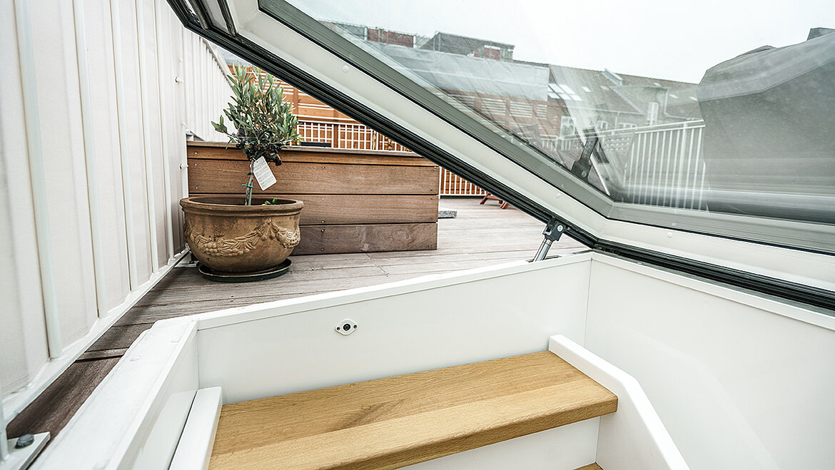 Moderner Flachdach Ausstieg mit Holztreppe zu einer stilvollen Dachterrasse.