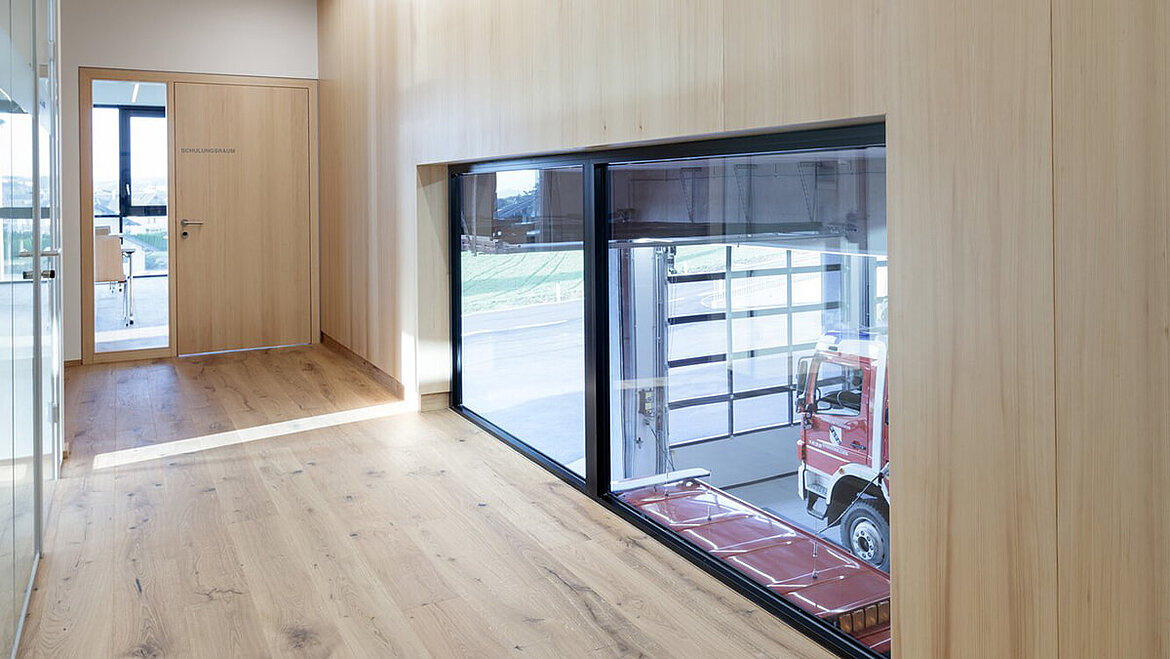Fenster vom Kindergarten in die Fahrzeughalle der Feuerwehr