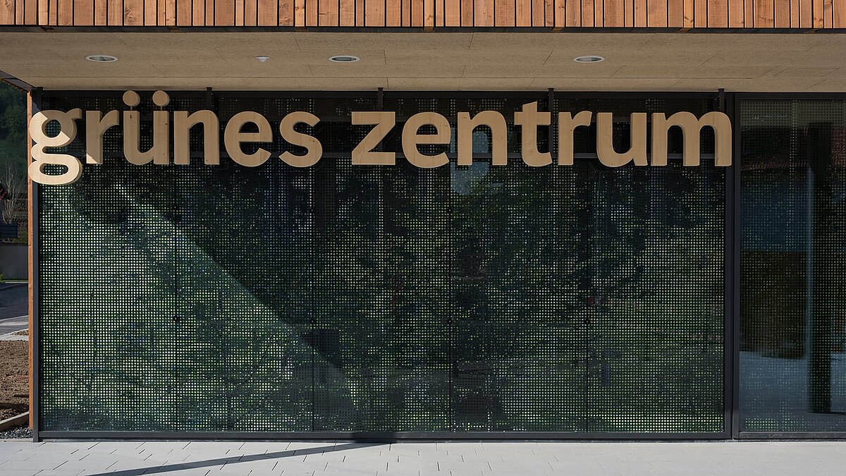 Eingangsbereich des Grünen Zentrums Immenstadt mit moderner Glasfassade und Holzschriftzug.
