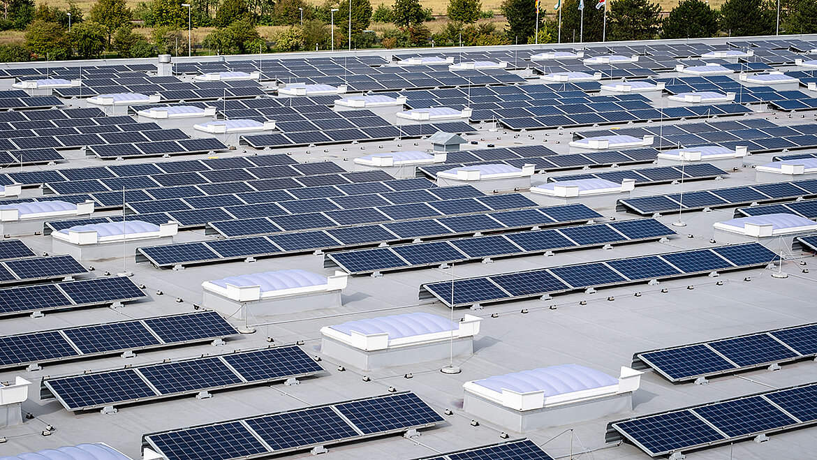 Industrieareal mit großflächiger Photovoltaikanlage und mehreren Lichtbändern auf Flachdächern