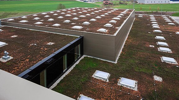Außenansicht vom Dach des Zaltech-Gebäudes in Moosdorf, Österreich, mit LAMILUX Flachdach Fenstern F100 und runden Flachdach Fenstern FE.