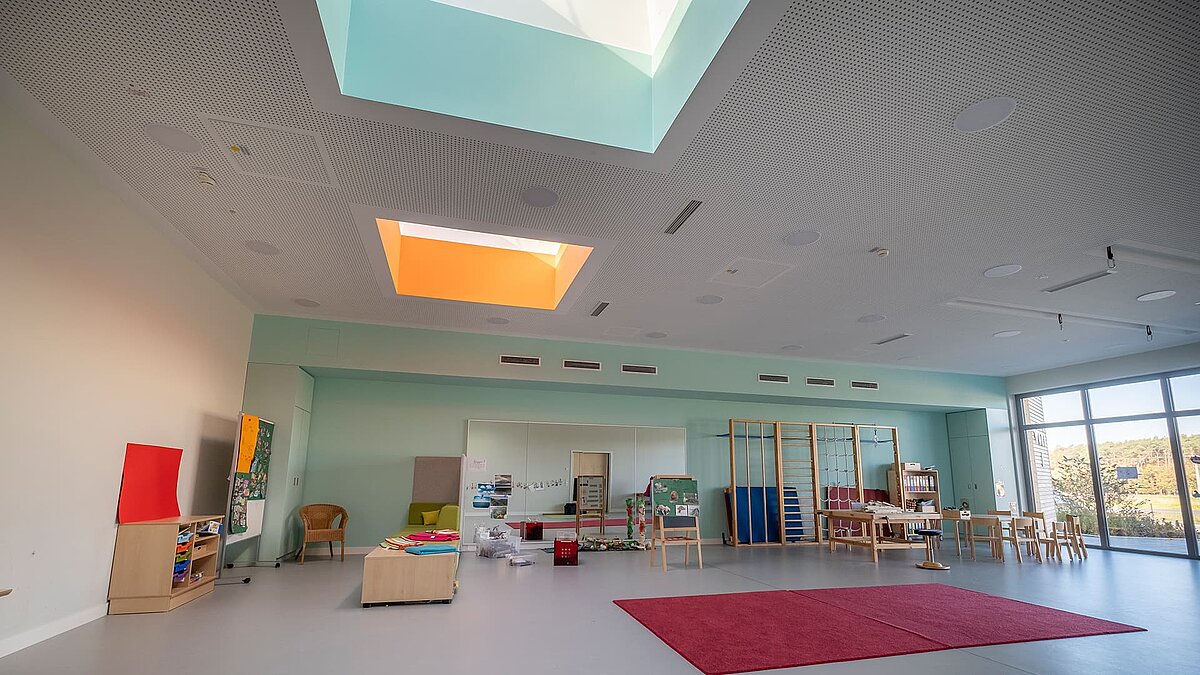 Gruppenraum im Kindergarten „World of Kids“ mit LAMILUX Flachdachfenster FE 3° und Glasdach PR60, die für natürliches Licht sorgen.