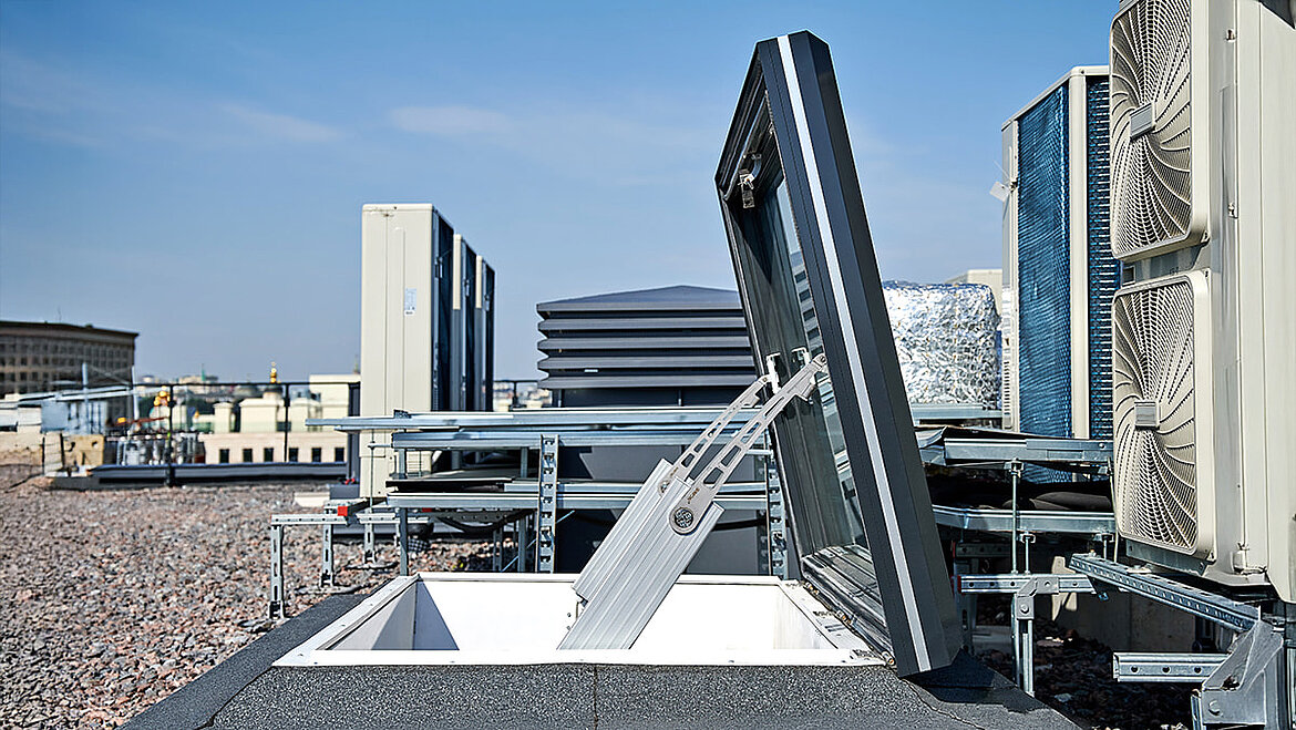 Aufklappbares Dachfenster auf Flachdach mit Blick auf Stadtgebäude