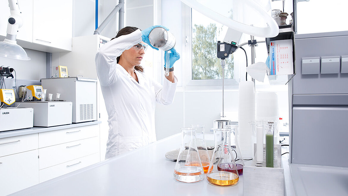 Chemikerin mischt im Labor verschiedene Flüssigkeiten zusammen