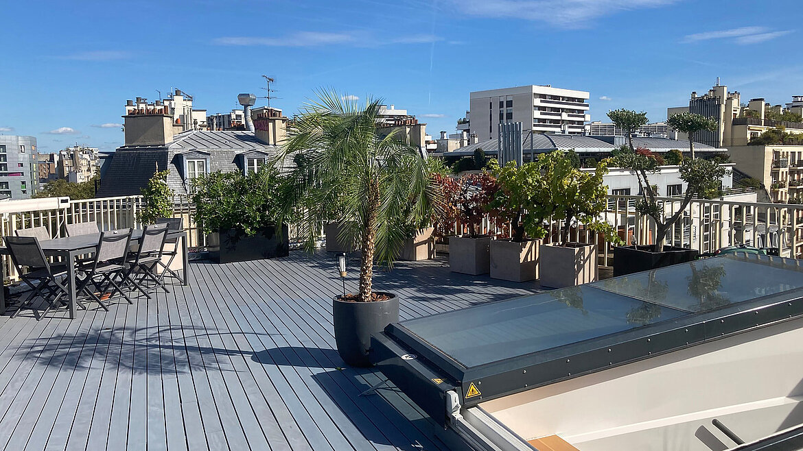 Moderne Dachterrasse mit Sitzbereich, Pflanzen und großem Dachausstieg mit Glasabdeckung