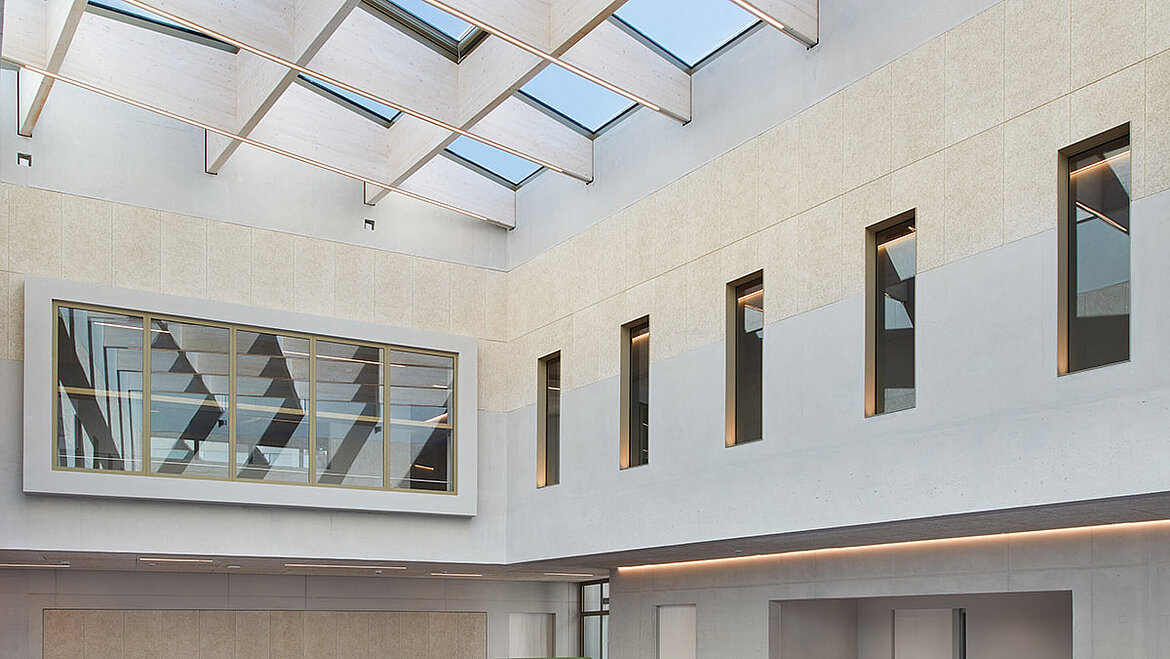 Helles Atrium einer Hochschule mit verschiedenen Fenstern und AMILUX Glasdachs PR60