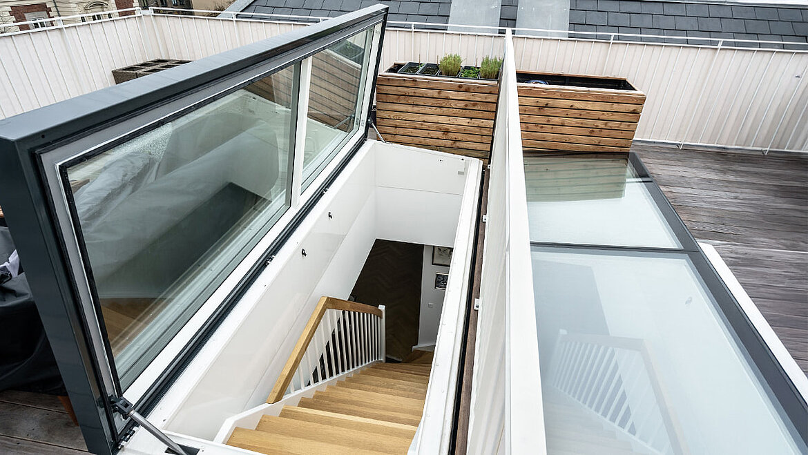 Offener Dachausstieg auf der Dachterrasse mit Blick ins Innere der Wohnung und Sicherheitsgeländer 