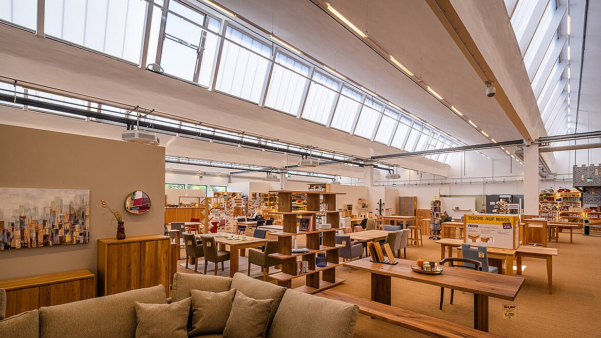 Helles Möbelgeschäft mit Oberlichtern und großen Ausstellungsflächen.