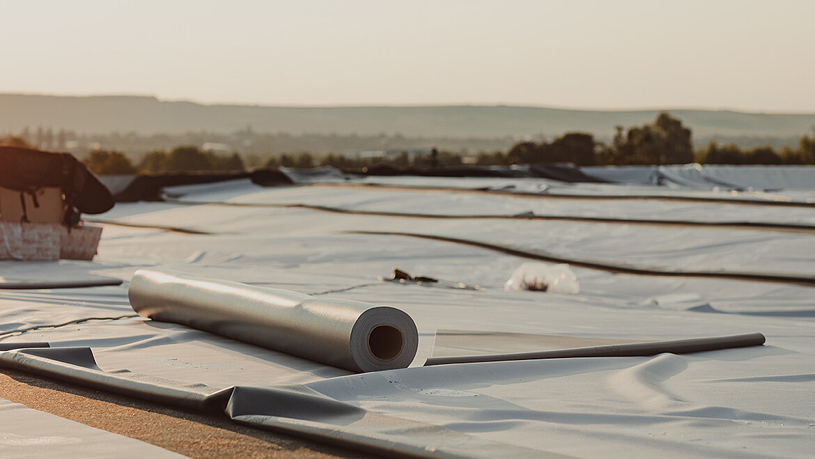 Flachdach mit verlegter Dampfsperre als Teil des Dachaufbaus im Abendlicht