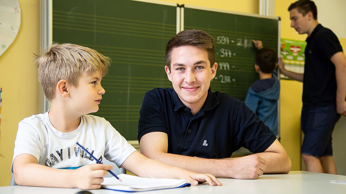 Azubi übt Mathematik mit Grundschüler Rechenförderung in der Grundschule | karriereblog by LAMILUX