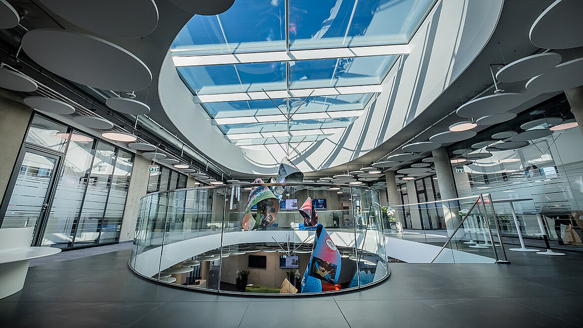 Modernes Atrium mit ovalem Glasdach und viel Tageslichteinfall.